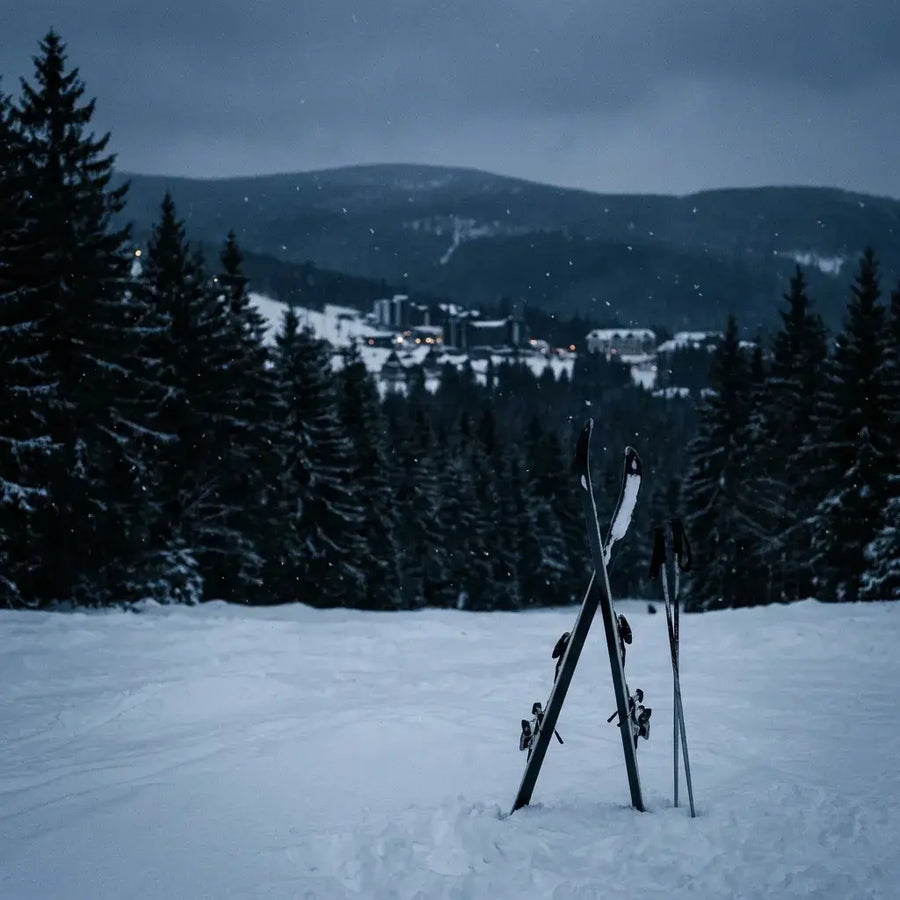 Skidor i en mörk snöig skidbacke